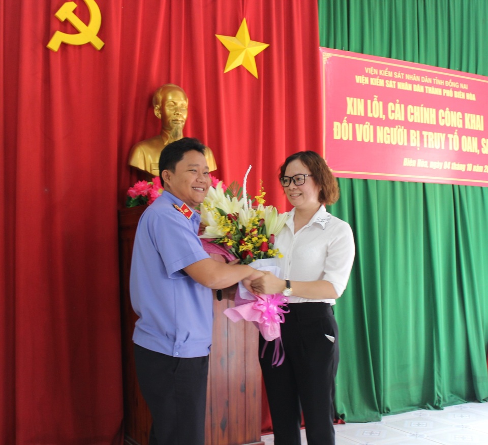 Xin lỗi công dân bị truy tố oan 7 năm trước - 1 Đại diện Viện Kiểm sát nhân dân tặng hoa xin lỗi người bị truy tố oan.