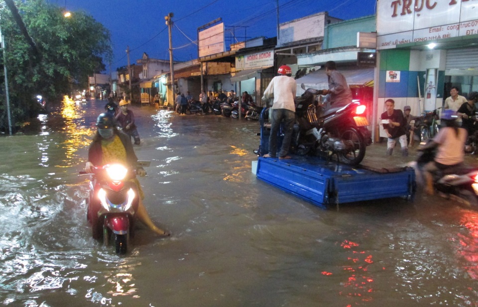Người Sài Gòn dắt xe lội nước về nhà - 1 Lúc 17h30, triều cường bắt đầu dâng cao và đạt đỉnh 1,68 m, nhiều tuyến đường như Huỳnh Tấn Phát (quận 7), Hồ Ngọc Lãm (Bình Tân), Quốc lộ 50 (Bình Chánh),… ngập nặng.