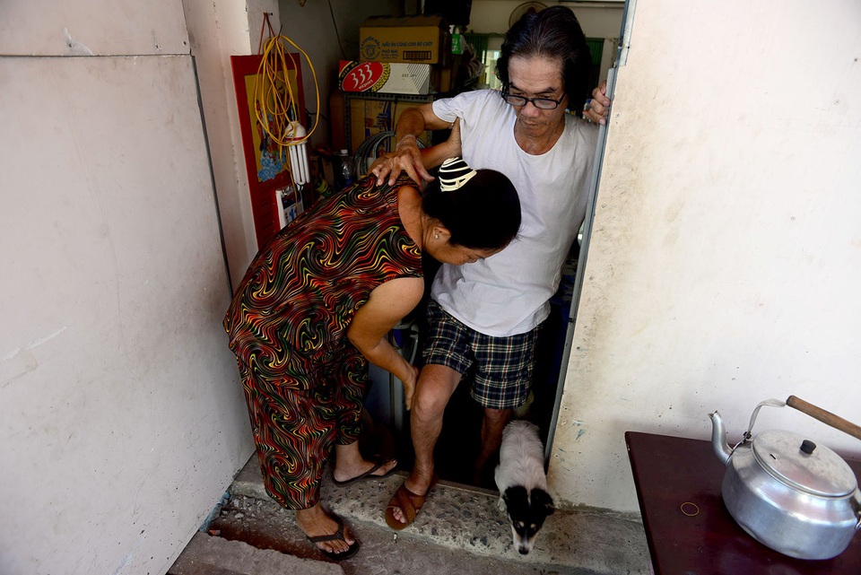 Mỗi lần muốn lên vỉa hè ngồi chơi, ông Chính phải nhờ vợ dìu từng chút bước lên bậc tam cấp làm tạm.