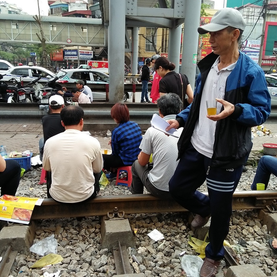 Hà Nội: Hãi hùng cảnh "họp chợ" trên đường ray tàu hỏa - 5
Nhiều người dân cho hay, trong bệnh viện bí bách lại chật chội nên họ tranh thủ ra ngoài cổng viện uống nước hoặc ăn sáng cho thoáng. Mỗi khi có tàu chạy qua, cả người bán lẫn khách hàng cùng ôm ghế đứng tránh sang hai bên, đợi khi tàu đi qua rồi, cảnh buôn bán tấp nập lại diễn ra bình thường.