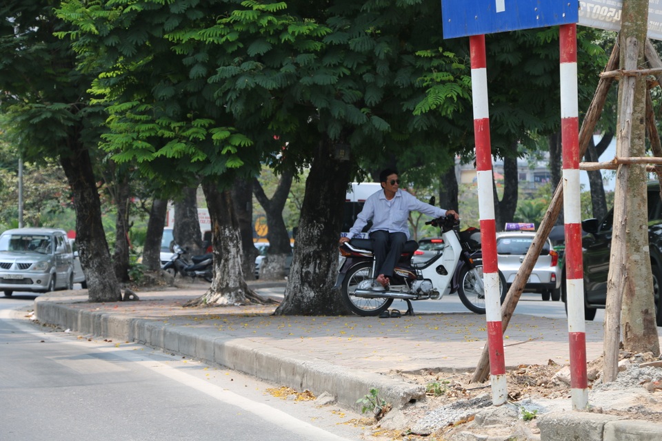 Nhọc nhằn những giấc ngủ trưa dưới nắng nóng của người lao động - 9 Chú xe ôm này cũng chọn cho mình chỗ đứng dưới tán cây rộng trên vỉa hè, tranh thủ nghỉ ngơi cũng như đợi khách đi xe ôm.