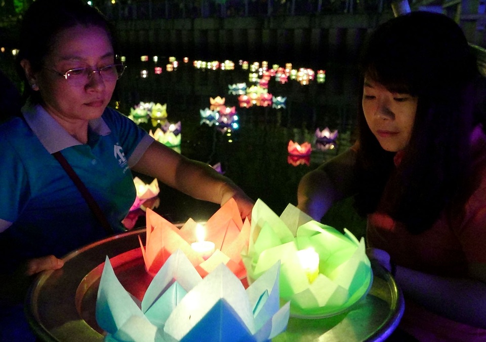 Hàng nghìn người Sài Gòn thả hoa đăng mừng lễ Phật đản - 13 Để tránh chen lấn do đông người, chùa Pháp Hoa bố trí người hỗ trợ nhận hoa đăng của mọi người rồi xếp vào mâm để đưa xuống sông.