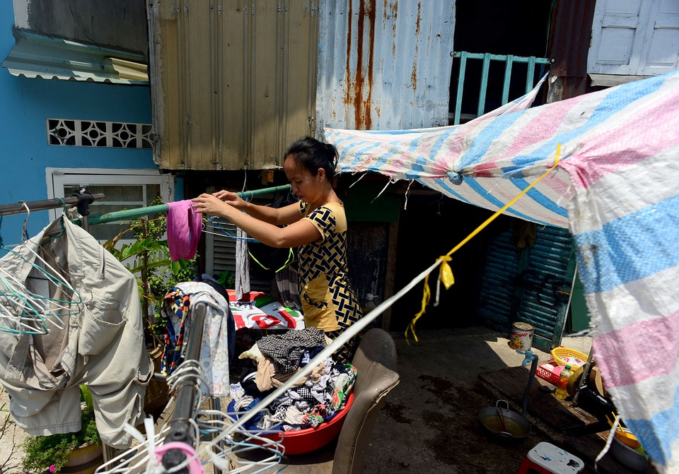  Nhà nhỏ, thấp hơn mặt đường nên buổi trưa nóng hầm hập, nhiều gia đình phải sinh hoạt ngay trên vỉa hè trước nhà.