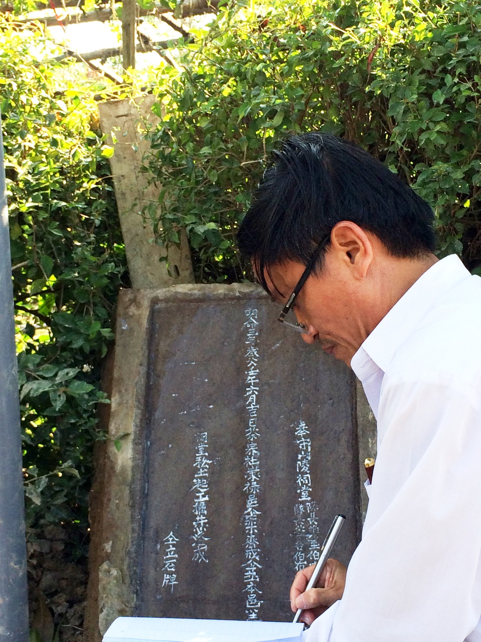 Ông Nguyễn Trường Ngợi đang dịch văn bia trên giếng cổ