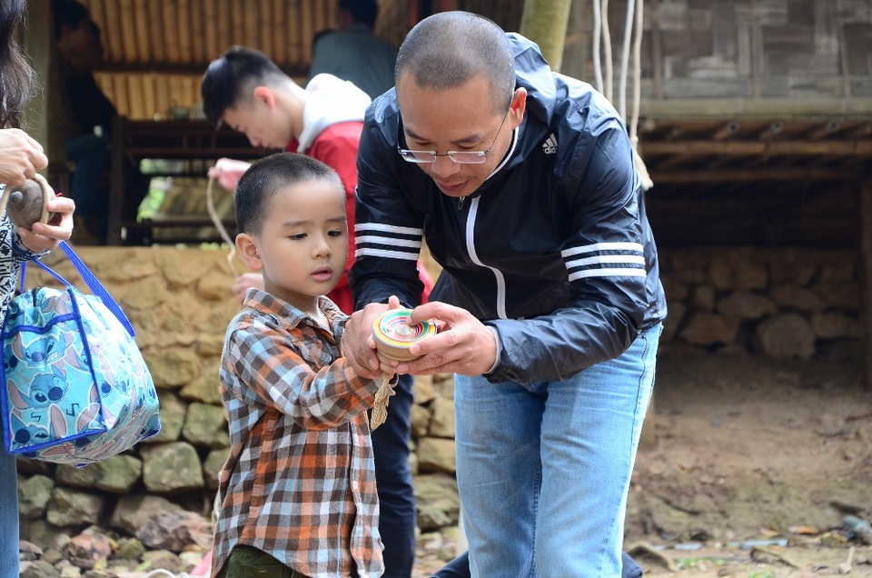 Trẻ nhỏ Hà Nội thích thú trải nhiệm tết vùng cao Tây Bắc - 6
Em nhỏ thích thú khi được bố dạy cách chơi quay của người dân tộc vùng cao.