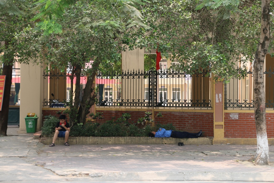 Nhọc nhằn những giấc ngủ trưa dưới nắng nóng của người lao động - 7 Ngoài gầm cầu vượt, vỉa hè có bóng cây râm mát cũng khiến giấc ngủ trưa của chú bảo vệ này dường như ngon lành hơn dưới cái nắng đầu hè.