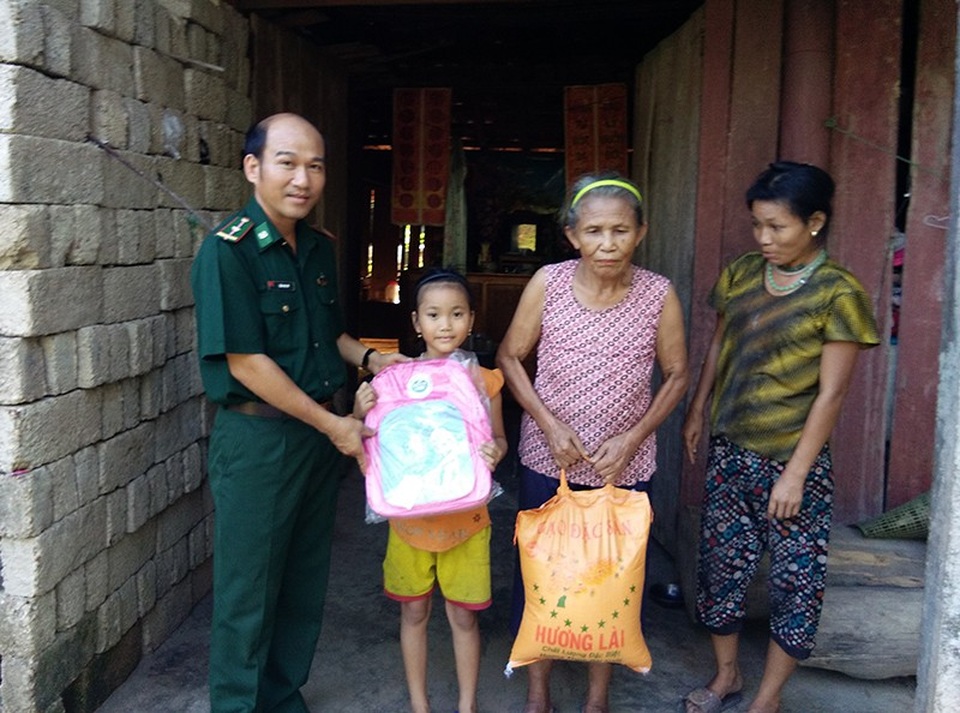 Chiến sĩ bộ đội biên phòng đỡ đầu cho 3 học trò khó khăn tới trường - 1 Đại uý Nguyễn Văn Vỹ (người đứng ngoài cùng bên trái ảnh) tặng cặp sách, gạo cho học trò và gia đình. Anh hiện đang đỡ đầu cho 3 học sinh nghèo để các em có điều kiện cắp sách tới trường.