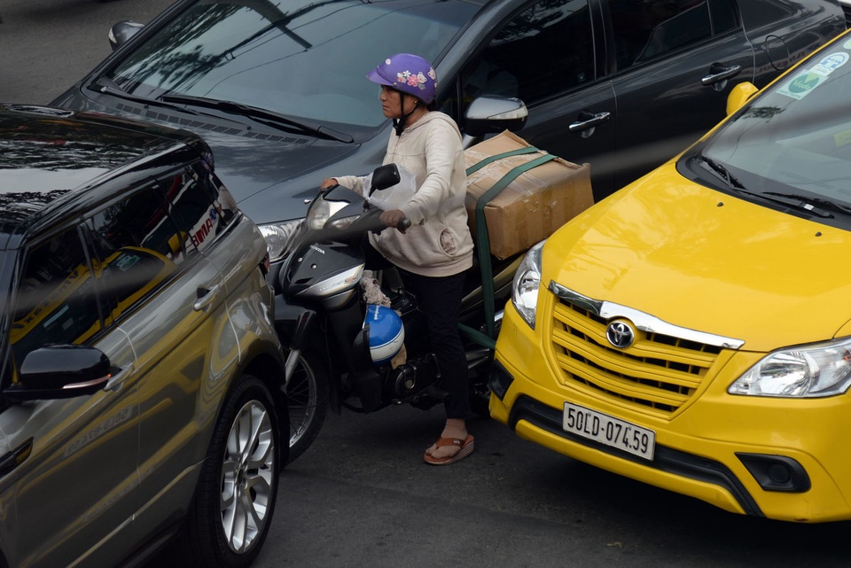 Người phụ nữ bị kẹt giữa 3 chiếc ô tô trên đường.