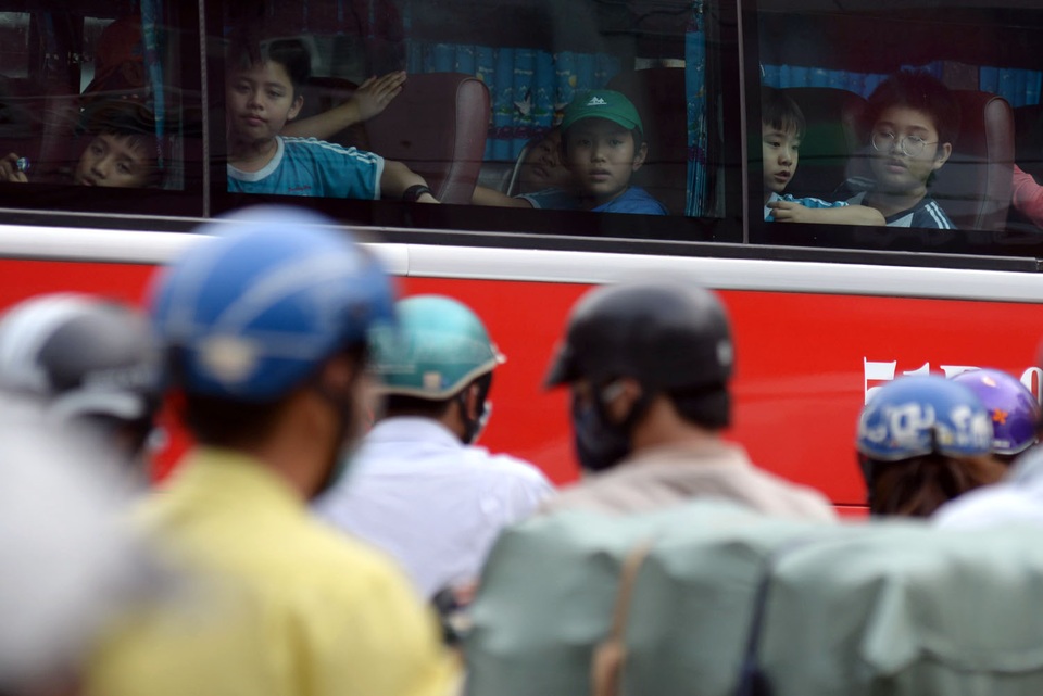 Các em học sinh của 1 trường tiểu học ngó nghiêng các phương tiện cố thoát ra khỏi đoạn đường kẹt xe.