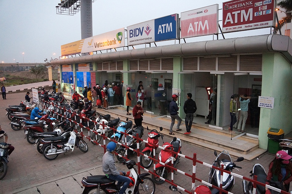 Chiều muộn ngày 25 tháng 1 (28 Tết), hàng chục công nhân làm việc tại khu công nghiệp bắc Thăng Long (Hà Nội) vẫn xếp hàng chờ đến lượt để rút tiền về mua sắm Tết.