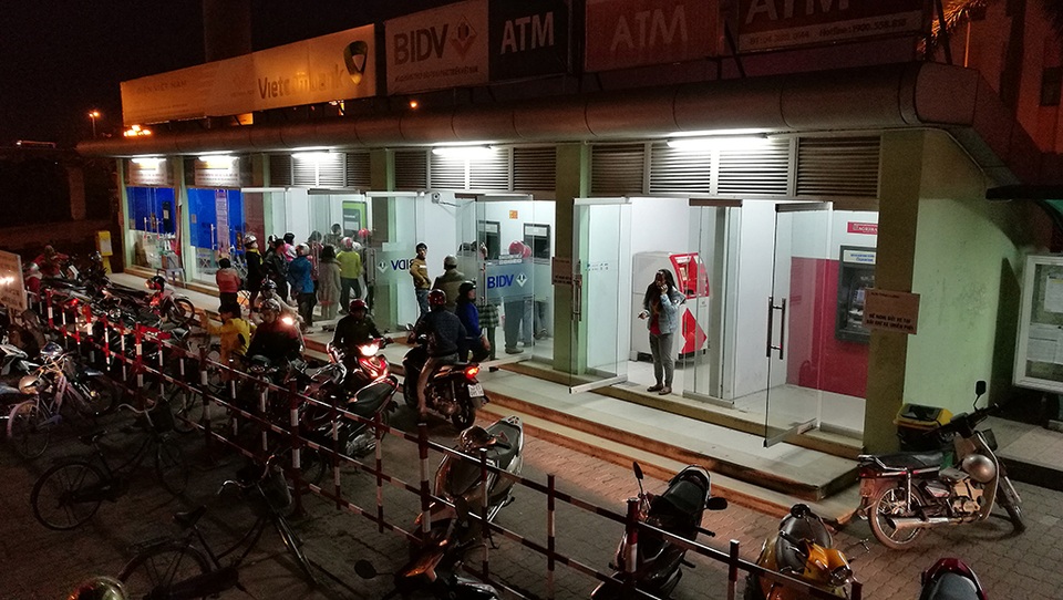 Đến hơn 20 giờ tối. Nhiều người vẫn phải đứng xếp hàng chờ rút tiền ở một số cây còn lại.