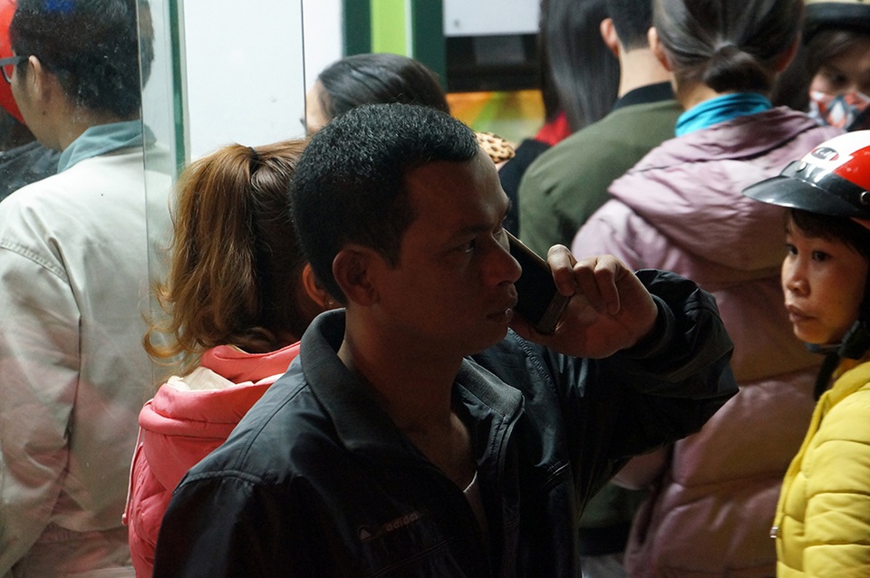 Một khách hàng liên tục bị điện thoại người nhà hỏi và giục để kịp về quê do đứng xếp hàng ở đây đã quá lâu.