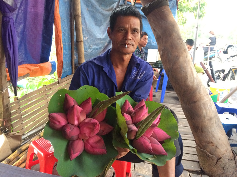 3 giờ sáng ra đầm hái sen, lão nông thu tiền triệu mỗi ngày - 1 Ông Đàm ôm hoa đi bán tại các chợ