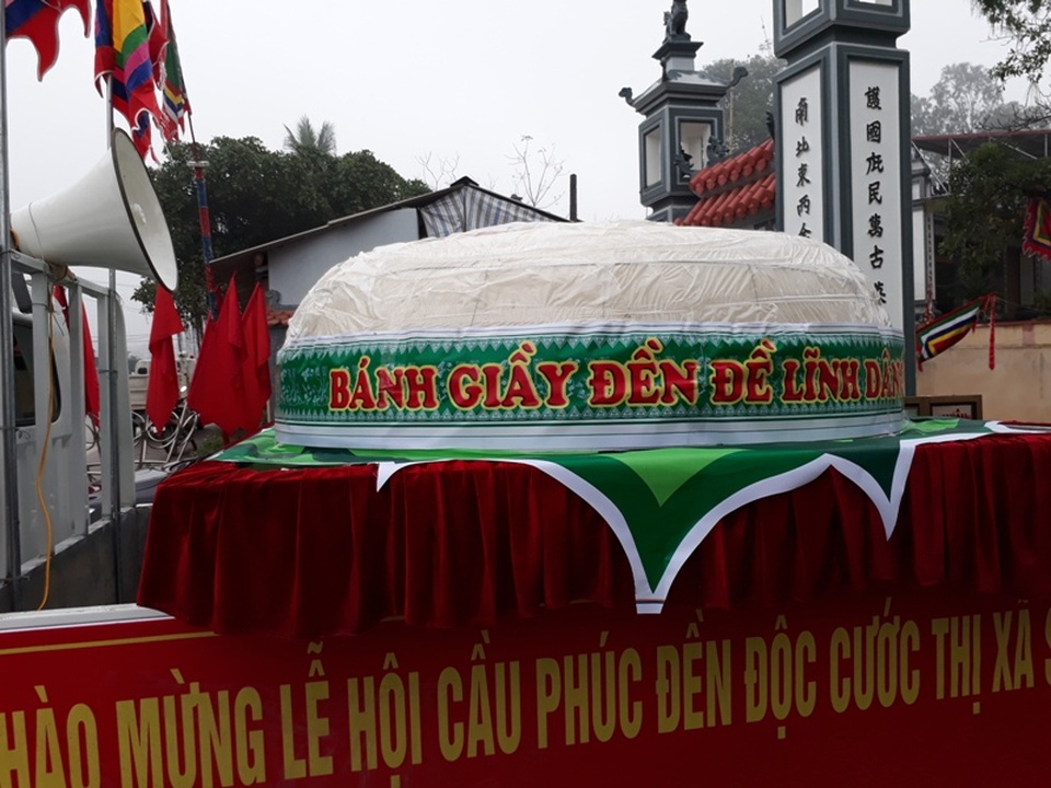 Dùng cần cẩu, ô tô vận chuyển chiếc bánh dày khổng lồ - 1 Đúng 7h sáng ngày 12/3, chiếc bánh bắt đầu được đưa rước về đền Độc Cước