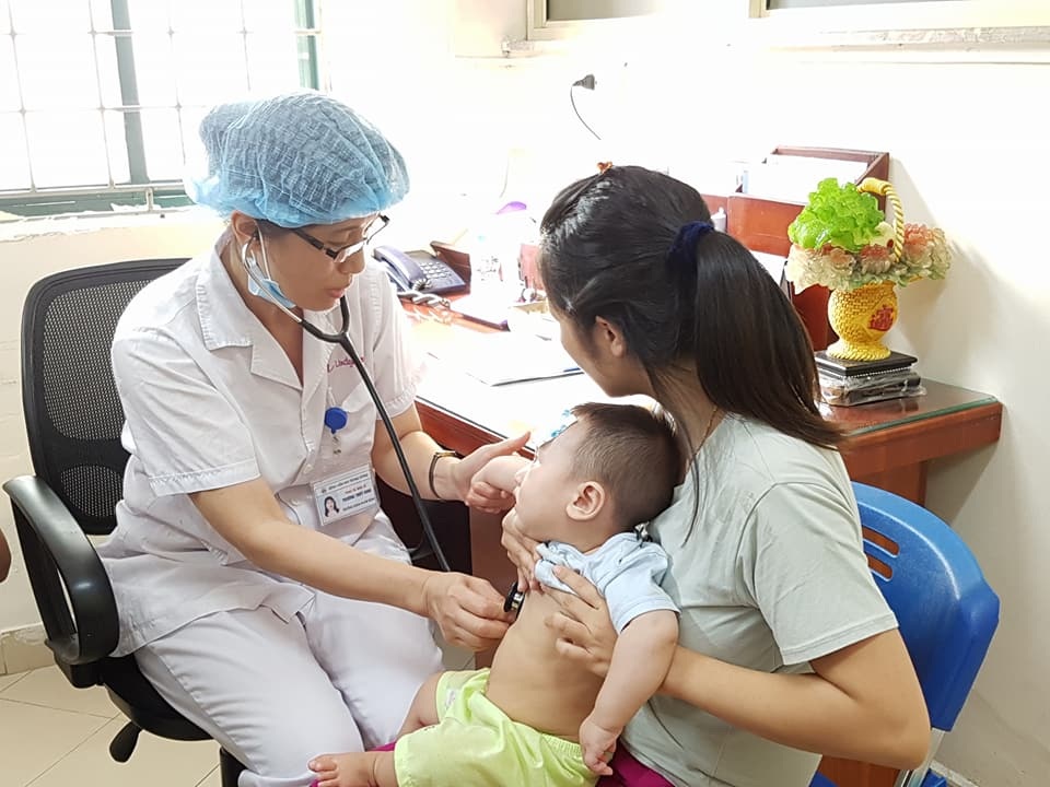 Chuyên gia nhi khuyên uống nước dừa, oresol để đối phó nắng nóng - 1 Bệnh nhi đến khám phần lớn sốt vi rút, sốt cao không hạ nhiệt. Trong ảnh BS Vinh đang khám cho bệnh nhi. Ảnh: H.Hải