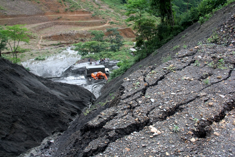 
Những rạn nứt của lớp đất đồi ở phía trên cao, có nguy cơ tiếp tục sạt lở khi trời mưa to. Ảnh: Văn Dũng - TTXVN
