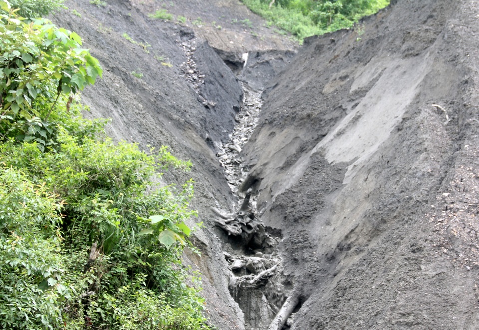 
Dòng nước chảy xiết từ trên núi đổ về cuốn theo lớp bùn, đất đá gây ách tắc đoạn đường Quốc lộ 12. Ảnh: Văn Dũng - TTXVN

