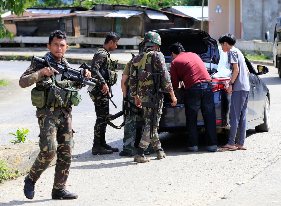 Philippines dốc sức giải phóng thành phố bị phiến quân chiếm đóng - 3 “Số hỏa lực được bắn ra từ phía đối phương không còn nhiều như trước. Có những khu vực từng diễn ra nhiều hoạt động của phiến quân thì nay dường như đã giảm bớt lại. Các vụ bắn tỉa cũng ít hơn”, Tướng Padilla cho biết, nhưng cũng thừa nhận rằng vẫn còn 3 ngôi làng trong thành phố hiện đang bị nhóm khủng bố chiếm đóng. Trong ảnh: Các thành viên của Lực lượng đặc nhiệm Cảnh sát quốc gia Philippines làm việc tại một chốt kiểm tra ở Marawi.