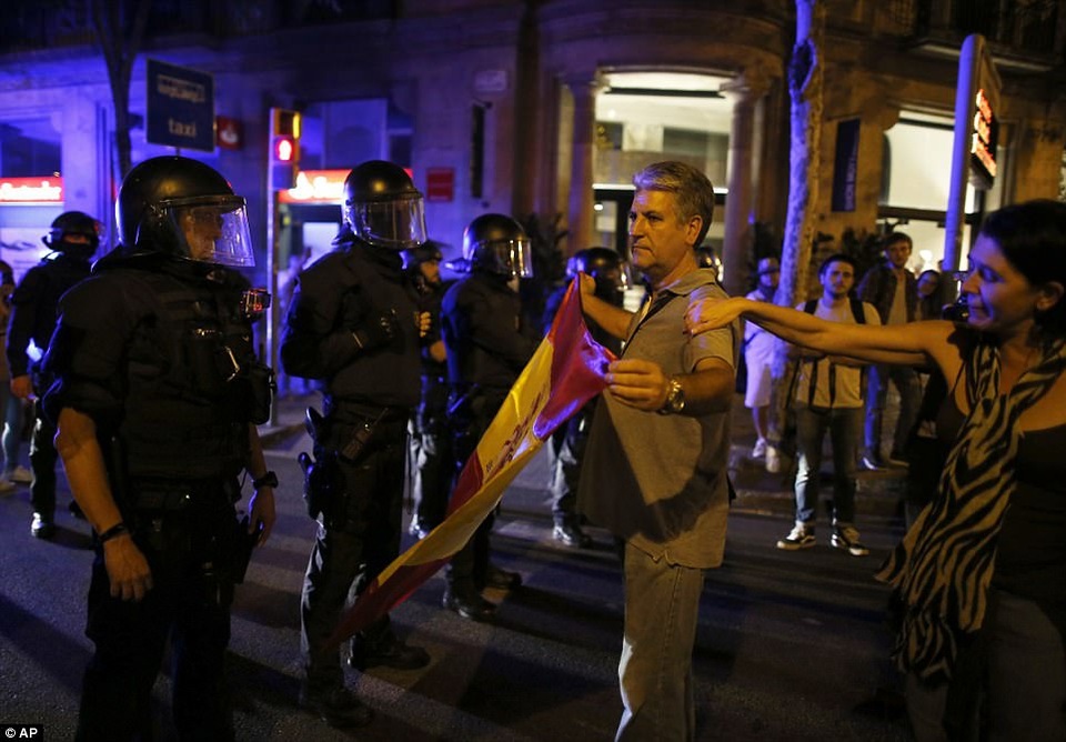 Hai thái cực đối lập tại Catalonia sau tuyên bố độc lập - 8
Công tố viên hàng đầu Tây Ban Nha giấu tên cảnh báo, những người có liên quan tới tuyên bố độc lập ở Catalonia có thể phải chịu hình phạt tù tới 25 năm vì hàng loạt cáo buộc phạm pháp. Nhà vua Tây Ban Nha Felipe VI cũng đã lên tiếng chỉ trích hành động của chính quyền Catalonia. Trong ảnh: Một người đàn ông cầm cờ Tây Ban Nha đứng trước cảnh sát Catalonia. (Ảnh: AP)