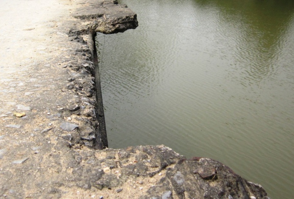 
Nhiều mảng bê tông mặt cầu rụng xuống sông.
