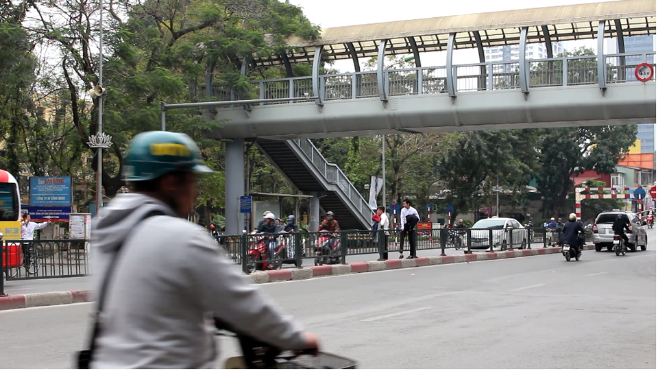 Người đi bộ thờ ơ với cầu vượt bộ hành - 2 Nhiều người vô tư trèo qua hàng rào chắn để đi sang đường.