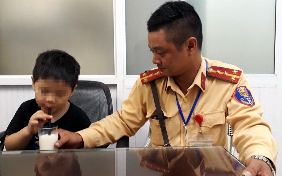 Đại úy Lê Hoàng Minh đưa cháu bé về trụ sở chăm sóc, tìm cách liên hệ với gia đình cháu.