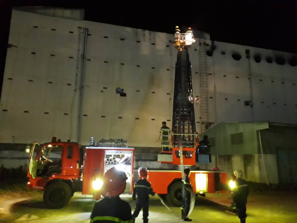 
21h15: Một xe thang của tỉnh Hậu Giang được điều bổ sung đến hiện trường vụ cháy, hỗ trợ làm mát từ phía sau của tòa nhà. (Ảnh: Phạm Tâm)
