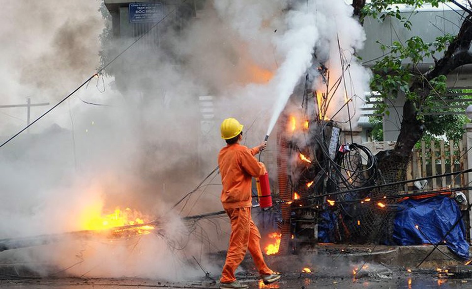 Hà Nội: Cột điện bốc cháy dữ dội giữa cơn mưa - 1 Lực lượng chức năng khống chế đám cháy.