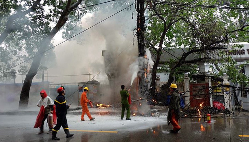 Hà Nội: Cột điện bốc cháy dữ dội giữa cơn mưa - 3
Lực lượng chức năng mặc áo mưa khống chế đám cháy.