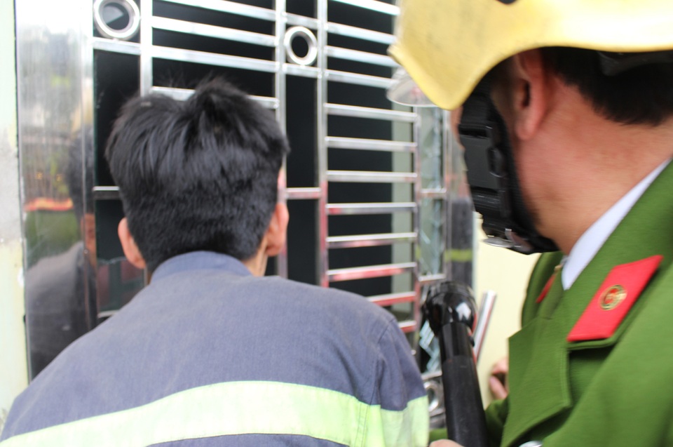 Giải cứu người già và trẻ nhỏ mắc kẹt trong hiệu thuốc bị cháy - 1 Lực lượng cứu hỏa phá cửa để vào tiếp cận khu vực bị cháy.