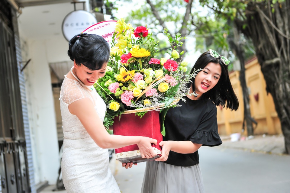 Hai mẹ con khệ nệ bê lẵng hoa vào cửa hàng trước khi bắt đầu làm lễ khai trương. Trong gia đình, Hồng Khanh là con út nhưng lại có nhiều tính cách giống mẹ nhất.