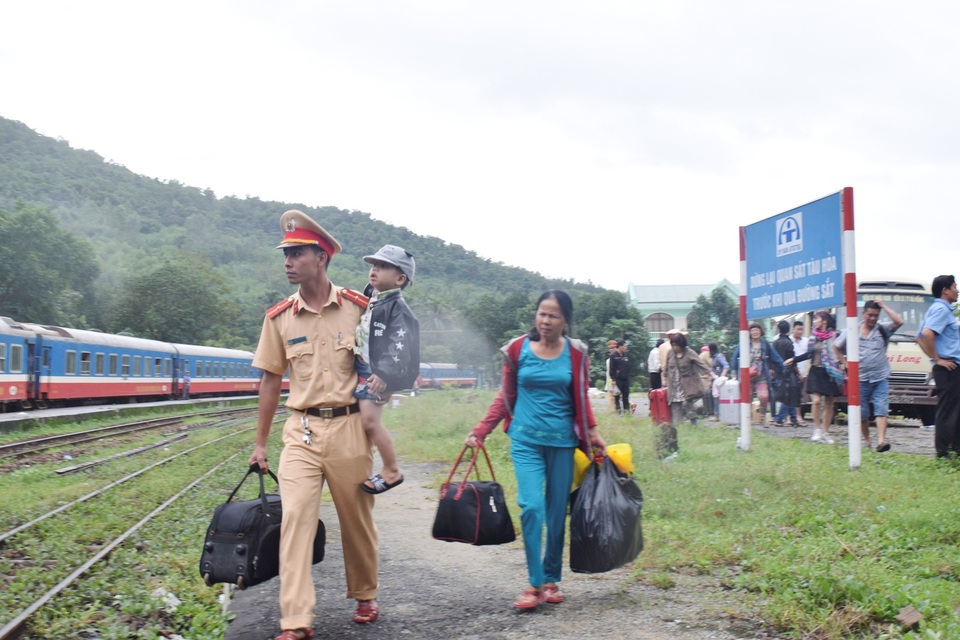 Đường sắt Bắc Nam qua đèo Hải Vân chính thức được thông tuyến - 7 Cảnh sát giao thông tỉnh Thừa Thiên Huế giúp người dân từ tàu lửa đang mắc kẹt từ Lăng Cô trung chuyển ra xe hơi để đi vào Đà Nẵng