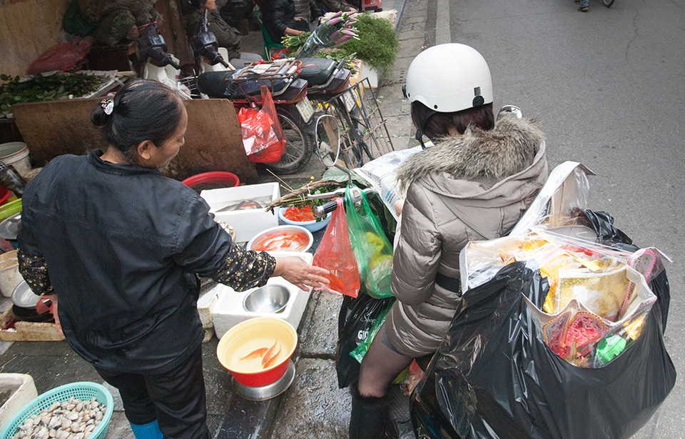 Hà Nội: Sắm Tết nhanh ở "chợ nhà giàu" - 9
Một khách hàng đi sắm lễ cho ngày ông Công ông Táo, trên xe máy có đủ thứ đồ. Đây cũng là cách đi chợ quen thuộc ở chợ Hàng Bè: chỉ mất 10 - 15 phút ngồi xe máy lướt qua chợ là có đủ mâm cúng ngày lễ, Tết.