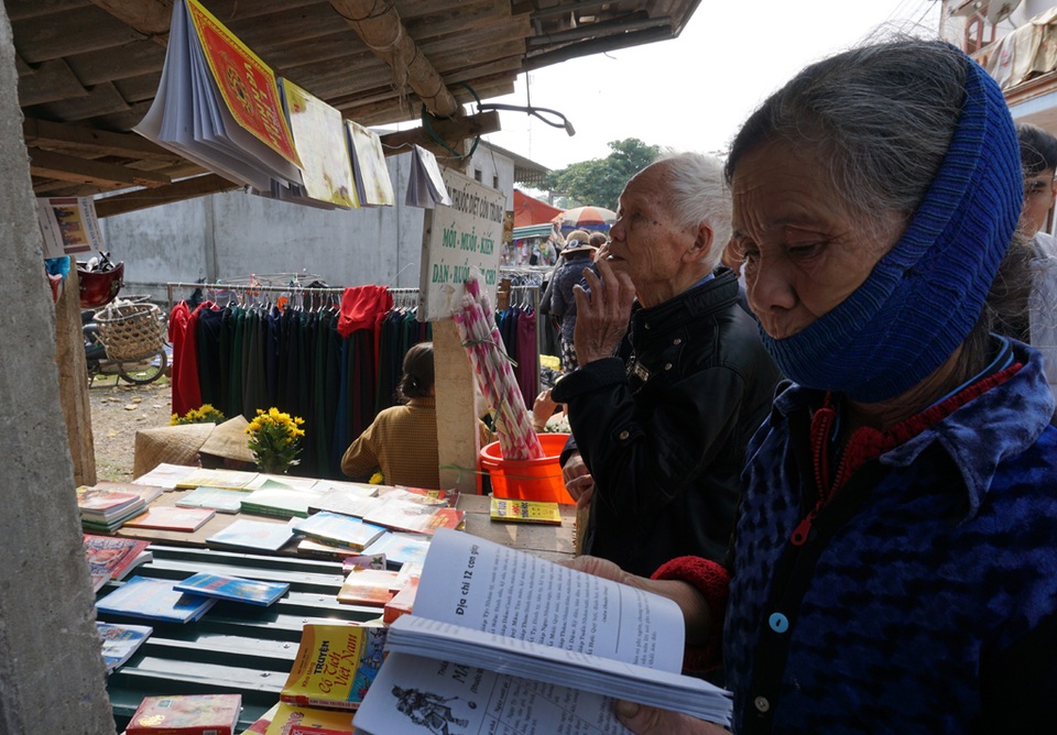 Các cụ già đang chọn sách tử vi để tự mình dự đoán vận mệnh của gia đình trong năm mới.
