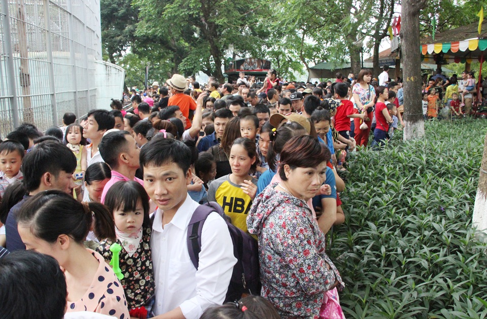 Hà Nội: "Biển người" đổ về công viên Thủ Lệ vui chơi ngày 30/4 - 8 Người đàn ông bế cháu nhỏ này đã phải toát mồ hôi mới chen được qua đám đông chật cứng.
