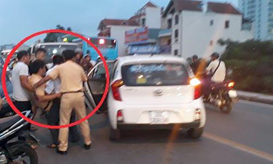 Nam thanh niên đâm gãy chân CSGT được bố đưa ra đầu thú - 1 Trung tá Khánh được đưa lên xe taxi để vào viện điều trị (Ảnh: Otofun).