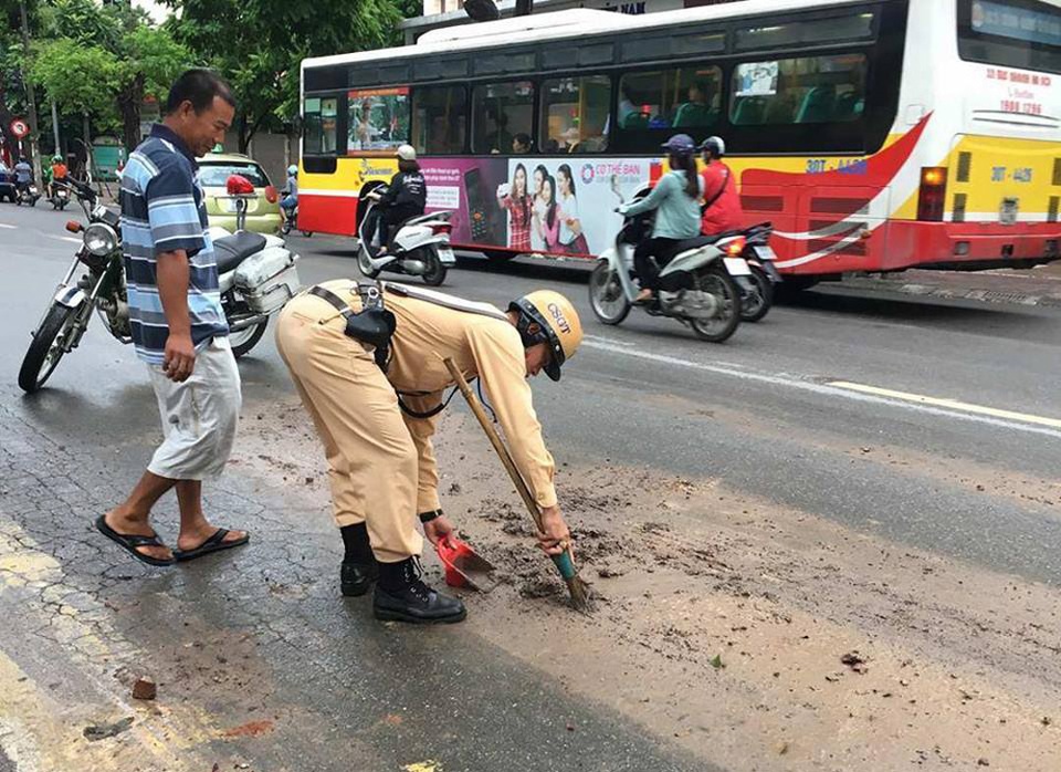 CSGT Hà Nội dừng xe thu dọn bùn đất vương vãi trên đường - 1