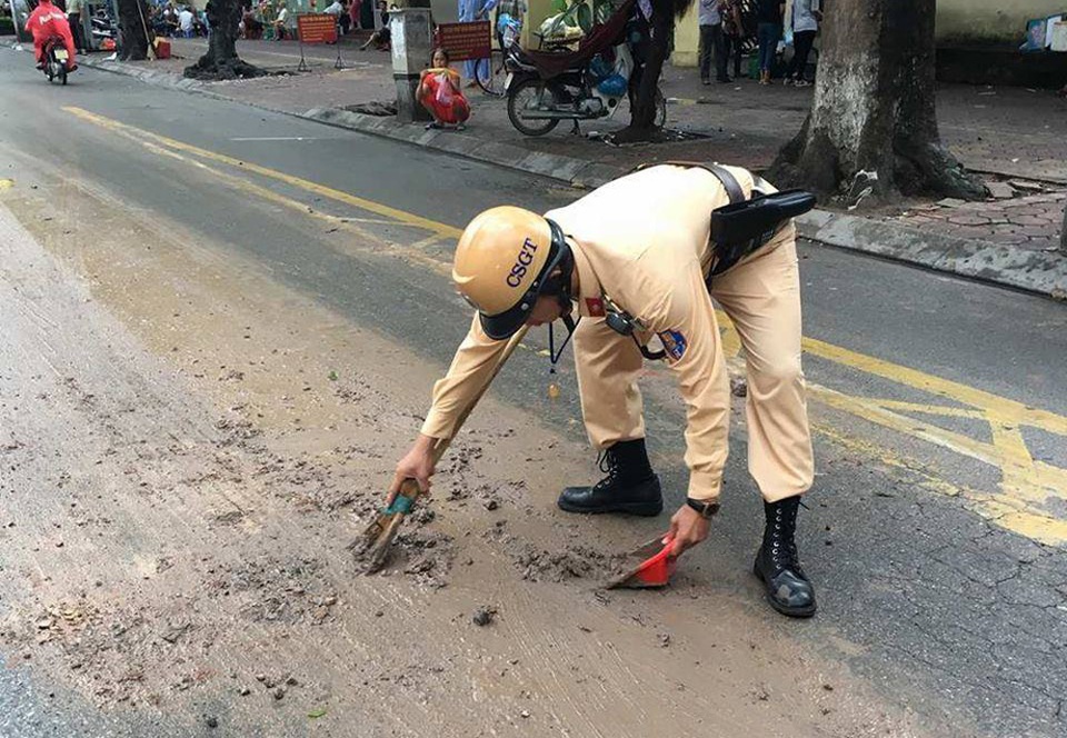 Hình ảnh chiến sĩ CSGT dọn bùn đất trên đường Hai Bà Trưng vào sáng nay (12/7).