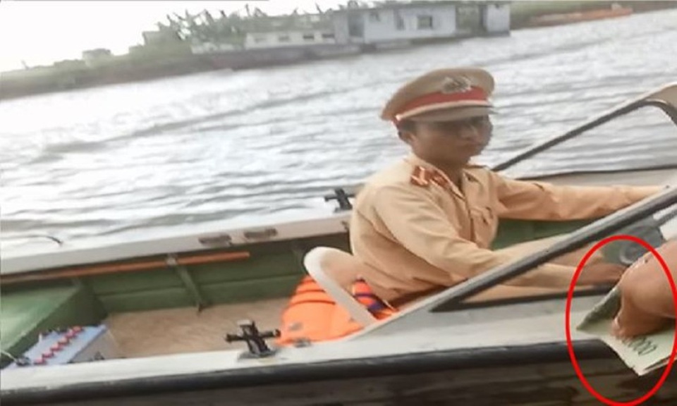 Đình chỉ 2 chiến sỹ CSGT nghi nhận mãi lộ trên sông - 1 Chiến sỹ CSGT Ninh Bình bị ghi lại hình ảnh nghi nhận mãi lộ trên sông Đáy trong lúc làm nhiệm vụ, đã bị đình chỉ công tác (ảnh: báo Tiền Phong)