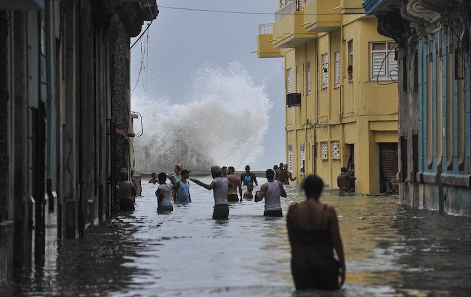 Cuba ngập trong biển nước sau siêu bão “quái vật” Irma - 2 Là cơn bão mạnh nhất ập vào Cuba kể từ năm 1932, siêu bão Irma đã hoành hành tại Cuba gần như trong cả 2 ngày cuối tuần qua trước khi đổ bộ vào bang Florida của Mỹ. Bão Irma đã khiến thủ đô Havana ngập trong biển nước, làm tốc mái các ngôi nhà và phá hủy các công trình tại quốc đảo Caribe này. Trong ảnh: Người dân Cuba đứng trên một con đường ngập lụt ở Havana hôm 10/9. (Ảnh: AFP)