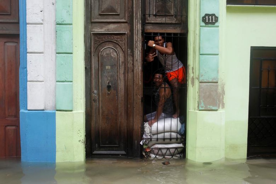 Cuba ngập trong biển nước sau siêu bão “quái vật” Irma - 6 Hơn 5.000 khách du lịch cũng được sơ tán khỏi các khu vực ở gần bãi biển phía bắc Cuba - nơi chính phủ xây dựng hàng chục khu nghỉ dưỡng trong những năm gần đây. Trong ảnh: Người dân dùng bao cát đặt trước cửa nhà để chắn nước tại Havana. (Ảnh: Reuters)