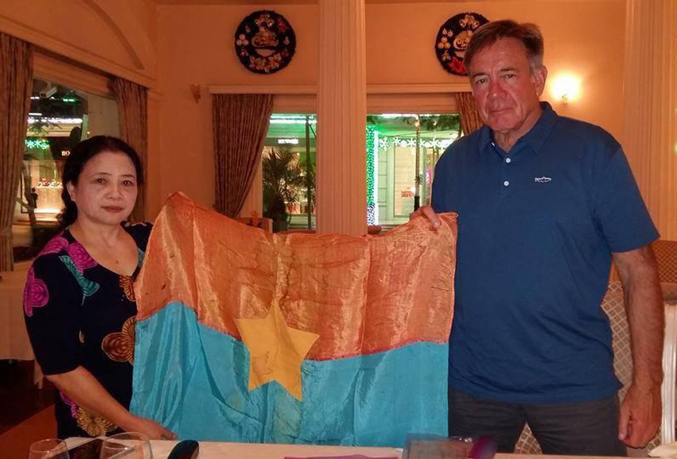 Lá cờ giải phóng thấm máu đào trở về từ bên kia chiến tuyến - 1 Denver Shannon trao lá cờ giải phóng vẫn còn nguyên vết máu cho Thượng tá Nguyễn Thị Tiến sau gần 50 năm cất giữ ở nước Mỹ.