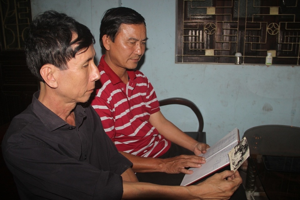 Những người lính Gạc Ma ngày ấy, bây giờ - 1 Hai cựu binh Trần Thiên Phụng và Võ Văn Doàn (áo đỏ) xem lại kỷ vật là bức ảnh của đồng đội đã hy sinh