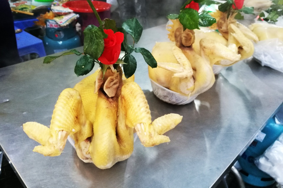 Hà Nội: Sắm Tết nhanh ở "chợ nhà giàu" - 5
Gà luộc sẵn bán ở chợ Hàng Bè có tiếng là ngon, hình thức cầu kỳ, đẹp mắt. Giá mỗi con khoảng 250 nghìn đồng, kèm thêm đĩa xôi gấc to là thành hơn 300 nghìn đồng, đắt hơn hẳn nơi khác.