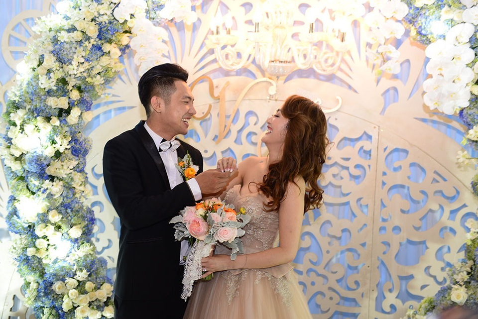 Hai vợ chồng vui vẻ, thoải mái trong tiệc cưới.