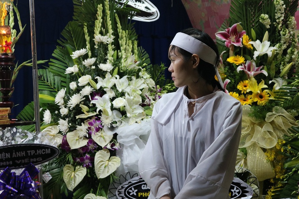Nhiều nghệ sĩ "đội mưa" tới viếng diễn viên Nguyễn Hoàng - 3 Vợ nam diễn viên khá lặng lẽ, thỉnh thoảng lại nhìn sang đi ảnh của chồng.