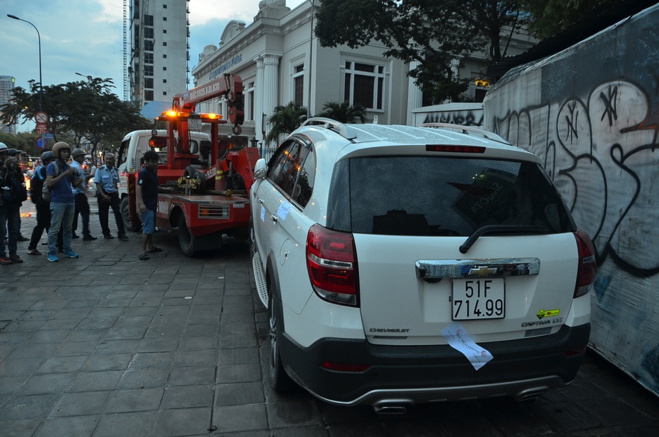 Một ô tô đậu trên vỉa hè bị cẩu đi