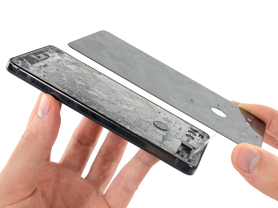 Nắp lưng đã tháo rời với lớp keo dày đặc ở bên dưới. Hãng này dùng loại keo stretch-release