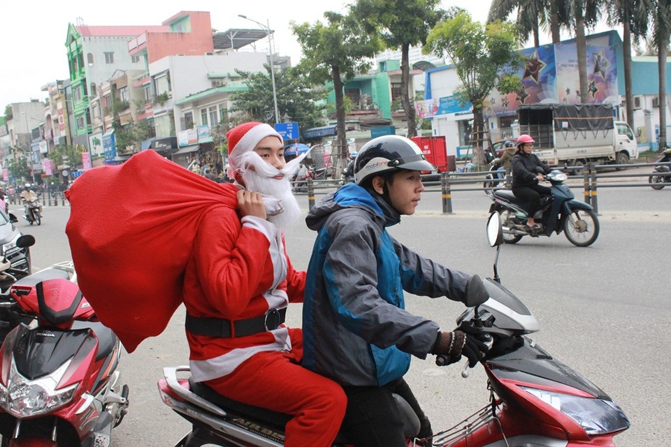 Dịch vụ “Ông già Noel tặng quà” hút khách trong mùa Noel - 1 Các bạn trẻ hóa thân thành ông già Noel nhận giao quà khắp các tuyến đường của thành phố