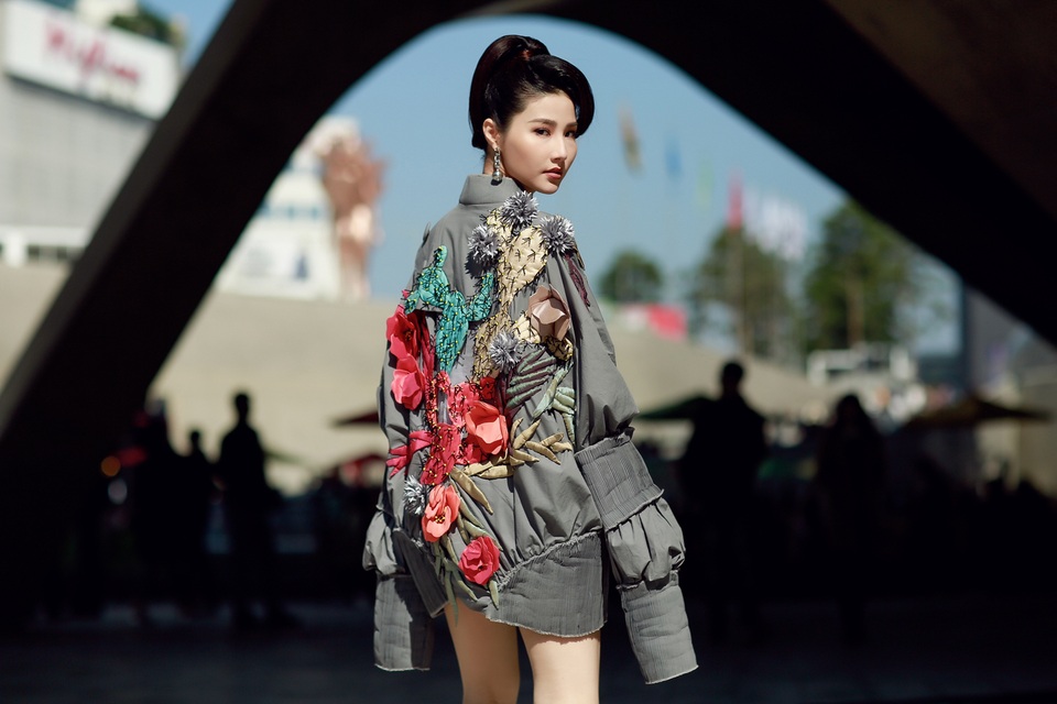 Thiết kế bomber giấu quần tạo nên điểm nhấn và độ nổi bật cho người đẹp. Vóc dáng mảnh mai của cô càng được tôn lên trong thiết kế “quá khổ” và ống tay dài. Tông xám bạc kết hợp cùng những chi tiết thêu ở phía sau lan ra sau thân áo vô cùng phù hợp với không gian hiện đại của một góc Seoul.